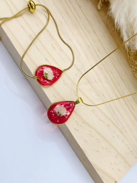 Komplet biżuterii handmade – naszyjnik i regulowana bransoletka z żywicy epoksydowej, zawieszki w kształcie kropli z czerwonym tłem, zatopionym białym kwiatem gipsówki i subtelnymi płatkami złota. Komplet biżuterii handmade – naszyjnik i regulowana bransoletka z żywicy epoksydowej, zawieszki w kształcie kropli z czerwonym tłem, zatopionym białym kwiatem gipsówki i subtelnymi płatkami złota.